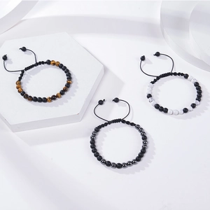 Détail de trois bracelets en pierre code Morse sur des supports géométriques blancs minimalistes