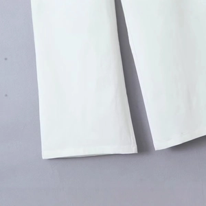Detailed shot of white low-waist cargo pants showing hem stitching and twill fabric texture