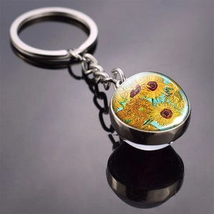 Close-up of metal keychain featuring Van Gogh Sunflowers art in a round glass dome