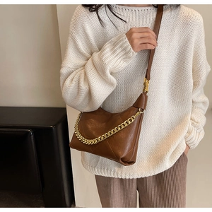 Close-up of brown quilted faux leather bucket bag with elegant metal chain strap detail