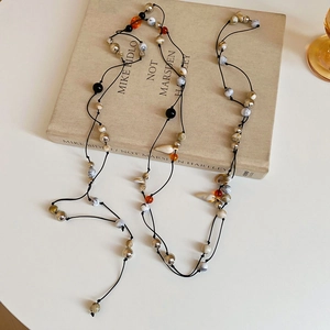 Detail of bohemian waist chain with acrylic beads and shell charms on vintage book