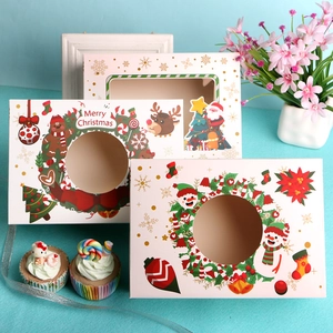 Christmas paper cupcake boxes with festive window designs featuring Santa and snowmen