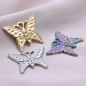 Detailed butterfly pendants in gold, silver, and rainbow steel on silk background