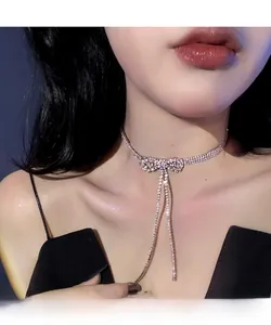 Close-up of a sparkling rhinestone bow choker with long tassels on a female model
