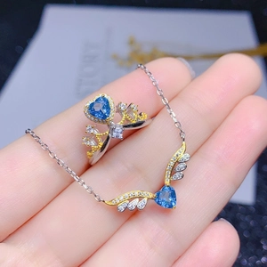 Detaillierte Ansicht des herzförmigen blauen Topas-Schmucksets mit Engelsflügel-Design