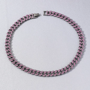 Hip hop silver Cuban link necklace with sparkling pink rhinestones on textured gray background