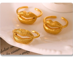 Detailed close-up of three gold smiling lip rings on a white textured plate