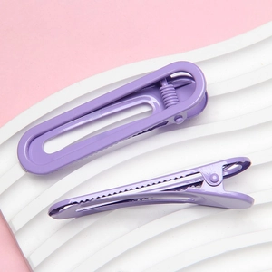 Detail view of purple lacquered 6cm U-shaped metal hair clip on wavy display base