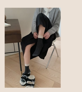 Détail de chaussettes en maille rayée avec bords-côtes dans un décor d'intérieur
