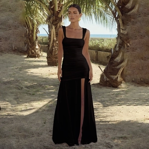 Detail view of black square neck dress with ruched bodice and high side slit on beach