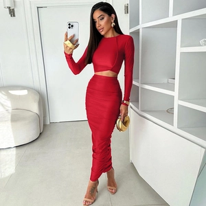 Dettaglio del crop top rosso a maniche lunghe e della gonna lunga arricciata coordinata