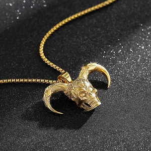 Macro shot of gold skull pendant with horns on sparkling black background with punk style