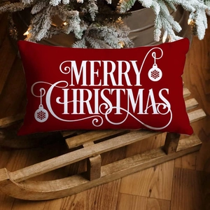 Detail of red Merry Christmas linen pillow cover on a wooden sled with tree background