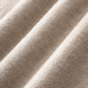 Makroaufnahme von fein gestricktem beige Wollstoff mit weicher hochdichter Webstruktur