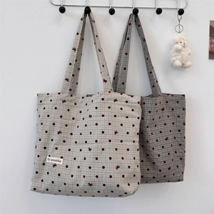 Detail of polka dot canvas tote bags with checkered pattern and durable shoulder straps