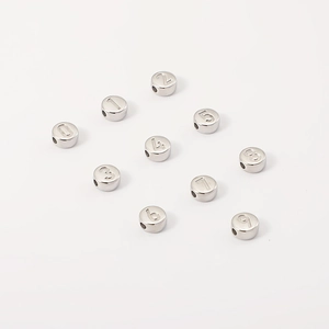 Macro-opname van 10 zilveren roestvrijstalen ronde kralen met cijfers 0-9 voor DIY sieraden
