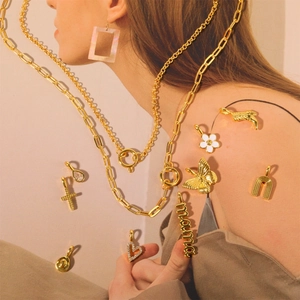 Detailed view of gold chain necklaces and charms including cross, heart, and mama motifs
