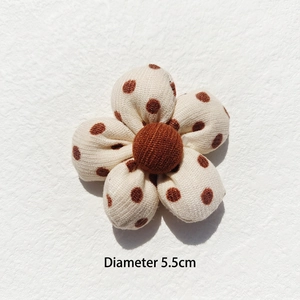 Detailed view of a 5.5cm handmade padded fabric flower with brown polka dots for DIY crafts