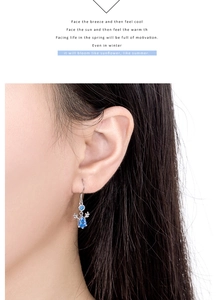 Close-up of elegant S925 silver elk horn earrings with drop-shaped blue gemstones