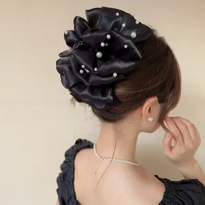 Dettaglio della pinza per capelli in raso nero con perle vista posteriore