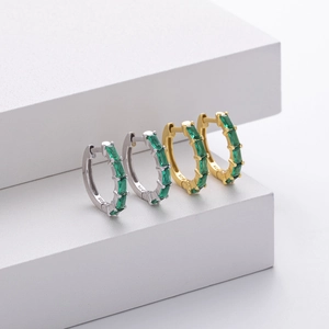 Detailed close-up of 925 sterling silver hoop earrings with rectangular emerald stones