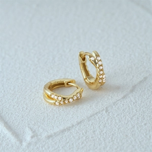 Macro detail of gold plated 925 sterling silver hoop earrings with sparkling cubic zirconia
