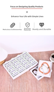 Detail view of white jewelry organizer tray with multiple compartments for rings and necklaces