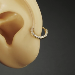 Gold-plated copper nose ring with white cubic zirconia inlay on a silicone ear model