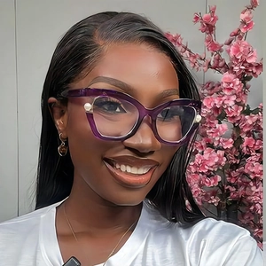 Close-up of cat-eye glasses with pearl accents on purple frames worn by a female model