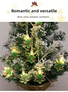 Detail of LED Christmas tree string lights with festive patterns on snowy pine branches