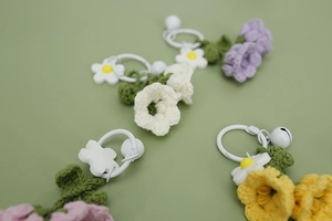 Detail of handmade crochet lily of the valley pendants with small bells and leaves