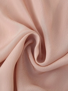 Vista macro dettagliata del tessuto satinato rosa cipria con drappeggio elegante e seta