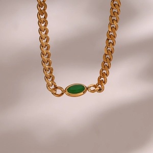 Detail of 18K gold-plated Cuban link necklace with an oval green stone pendant