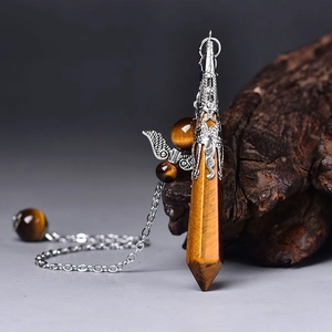 Detailed view of Tiger Eye crystal pendulum with vintage silver wing alloy setting