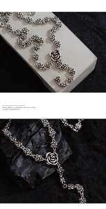 Macro detail of retro silver S925 rose pendant necklace on charcoal stone