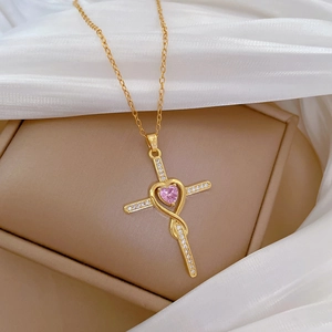 Macro view of gold cross necklace with pink heart gemstone and sparkling pavé diamonds