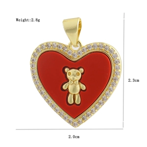 Detail of a gold heart pendant with red inlay, crystal edges, and golden bear motif