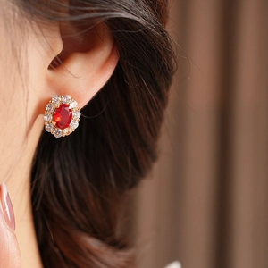 Nahaufnahme von Vintage-Ohrringen mit rotem Zirkon, elegant von einem Model getragen