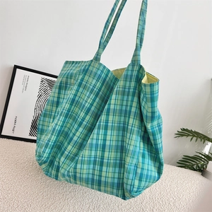 Détail du sac cabas à carreaux vert et bleu avec intérieur spacieux pour le travail