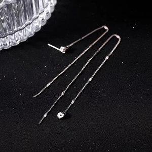 Elegant silver long tassel flower earrings with sparkling crystals on black silk background