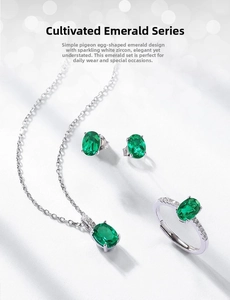 Detailed close-up of oval cut emerald jewelry set with silver four-prong settings