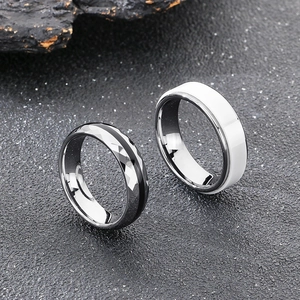 Dettaglio anello in acciaio al tungsteno sfaccettato e ceramica bianca su roccia