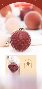 Detail of red and cream flocked Christmas ornaments with velvet texture and gold hooks