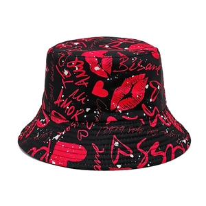 Detail of double-sided bucket hat with red lip prints and romantic graffiti on black fabric