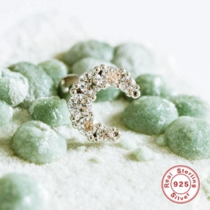 Macro shot of 925 sterling silver C-shaped ear piercing with sparkling zircon stones