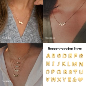 Close-up of gold stainless steel A-Z initial pendants on delicate O-chains for DIY jewelry