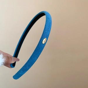 Détail d'un serre-tête en velours bleu avec plaque Love et doublure antidérapante