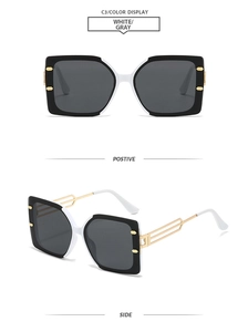 Detail view of square frame sunglasses with black and white splice and hollow metal temples
