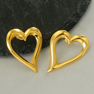Élégantes boucles d'oreilles cœur évidé en or sur fond texturé sombre style épuré