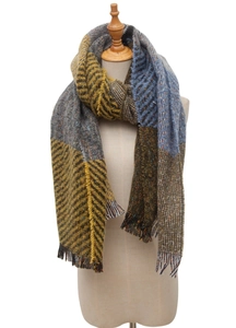 Detail of multi-color plaid scarf featuring yellow and blue fringe on a model